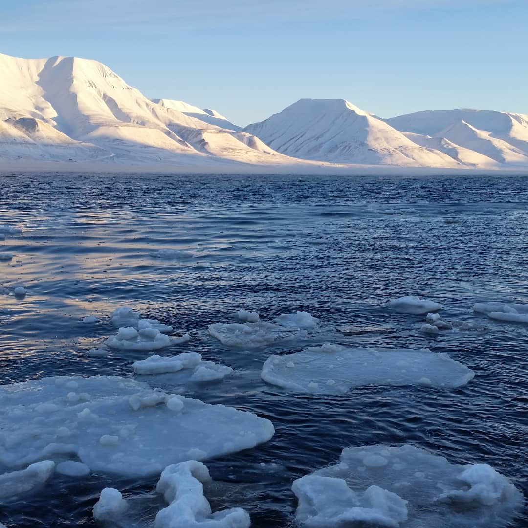 the sun reaches the hills surrounding Longyearbyen